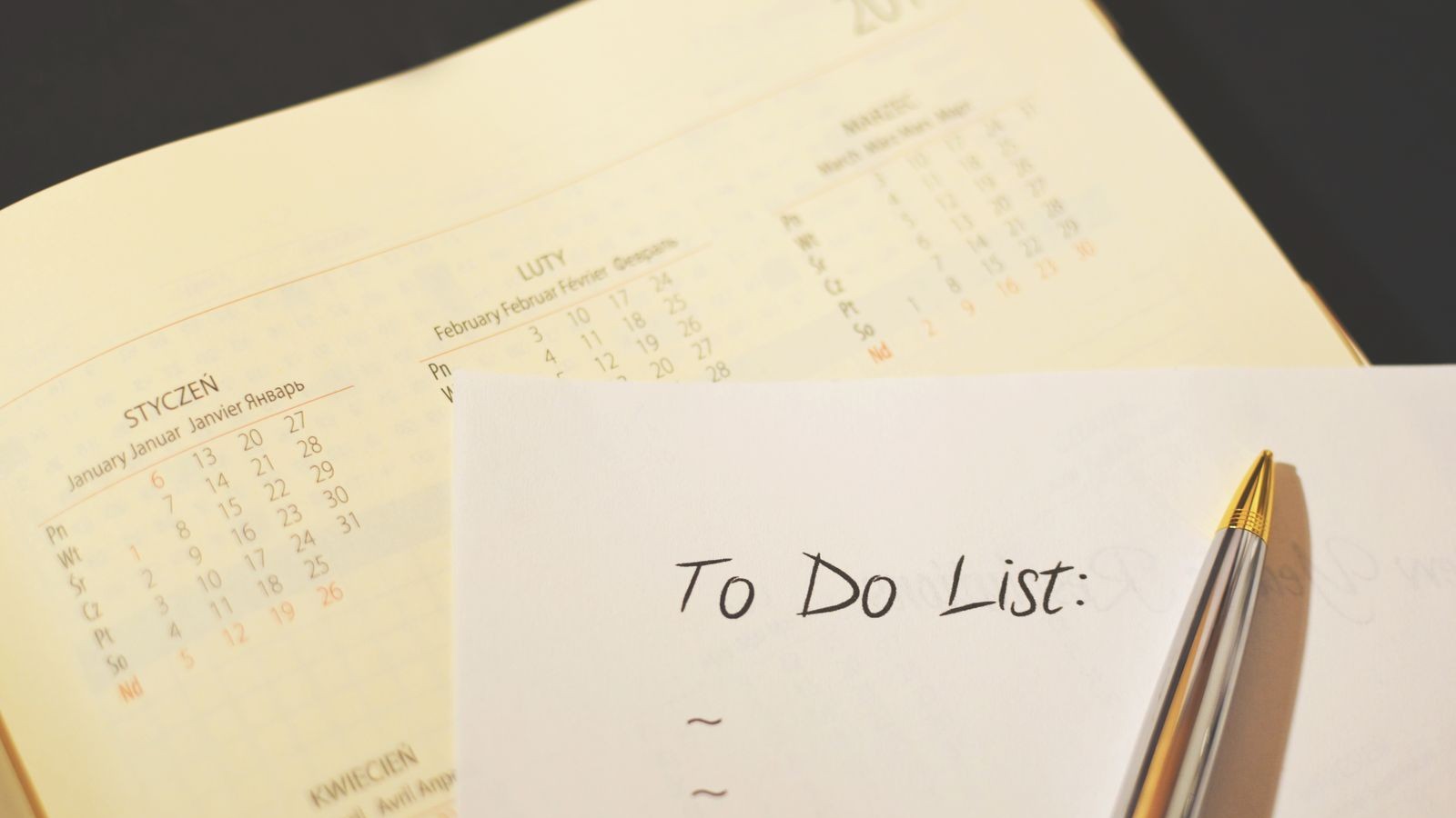 A checklist, pen, and binder clips arranged on a desk.