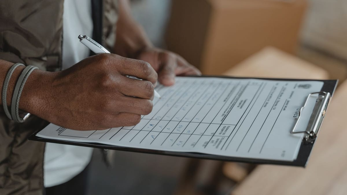 A person filling out a form on a clipboard.