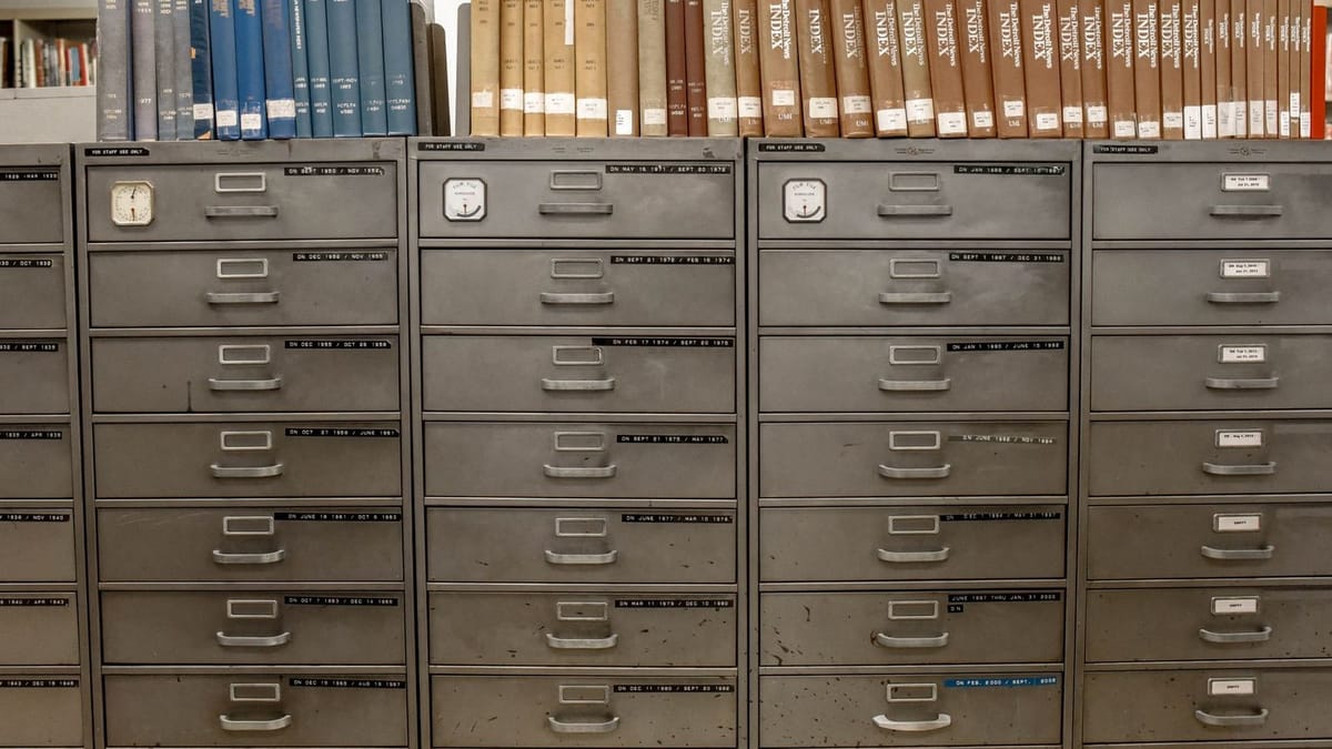 Rows of gray metal file cabinet drawers with books lined along the top.