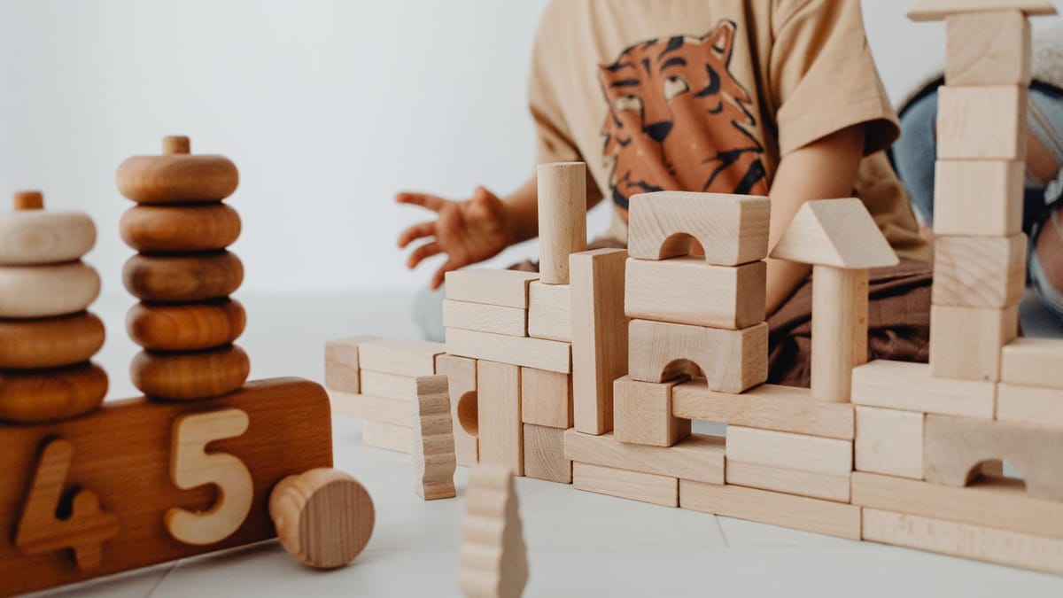Close-up of wooden building blocks stacked into a simple structure.