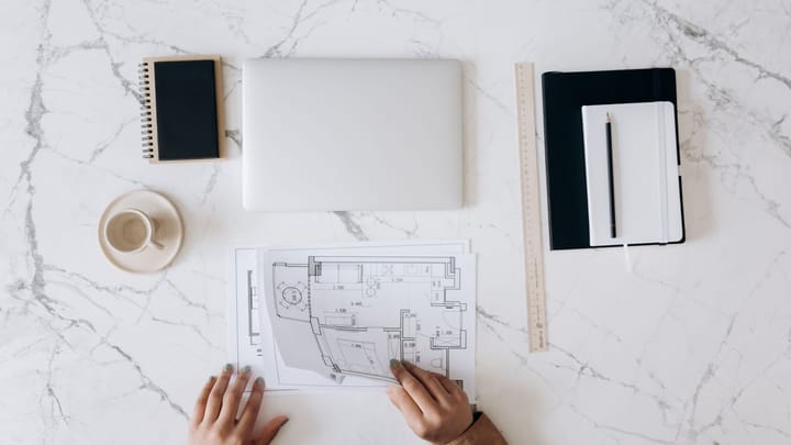 Architectural plans and tools on a work table.