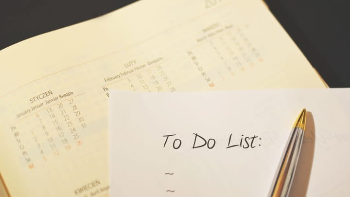 A pen resting on a paper to-do checklist.