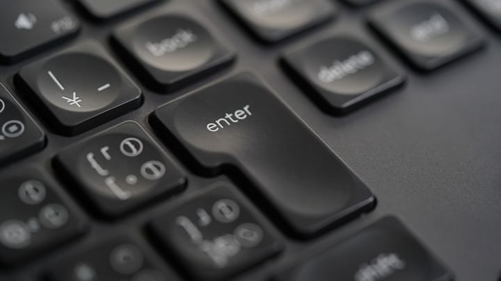 Close-up of the Enter key on a black keyboard.